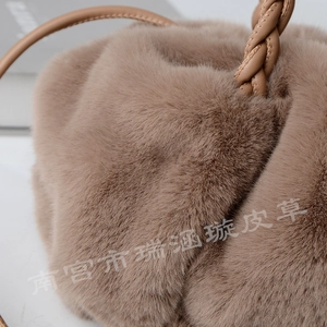 Macro shot of faux rabbit fur texture and braided handle on brown plush handbag