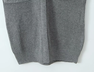 Close-up detail of grey knitted cardigan showing vertical ribbed texture and premium hemline