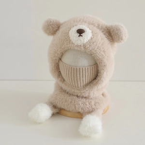 Détail du bonnet peluche beige pour enfant avec oreilles d'ours, masque et pompons doux