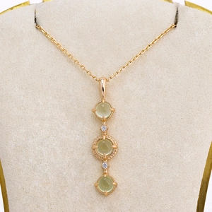 Elegant gold S925 silver necklace featuring three round green prehnite stones on a stand