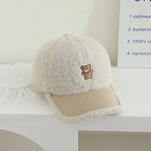 Detailed close-up of teddy bear embroidery on fleece baseball cap for children