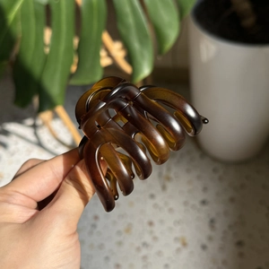 Detailed view of large dark brown amber resin hair claw clip with glossy finish