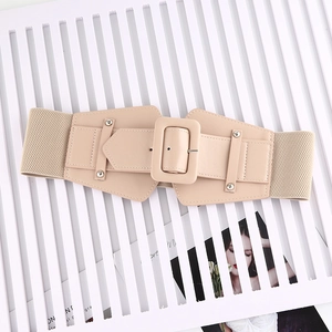 Detail of beige elastic waist belt with large square buckle and metal rivet studs