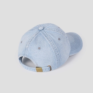 Detail of light blue washed denim baseball cap with vintage bronze metal buckle and strap