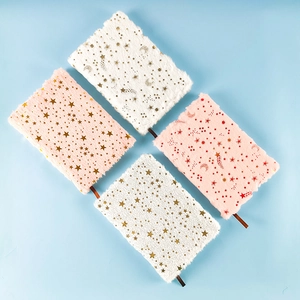 Detailed view of four fluffy plush notebooks with gold foil star and moon patterns