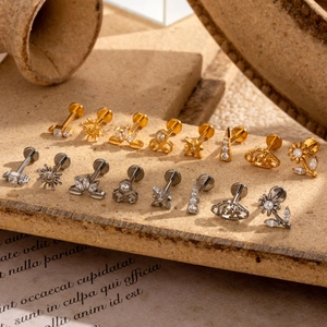 Macro shot of assorted G23 titanium lip studs and cartilage earrings in gold and silver