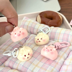 Close-up of cute steamed bun keychain pendants in pink and white with plastic hooks