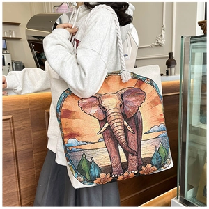 Detail of canvas tote bag showing colorful elephant embroidery and thick rope handle
