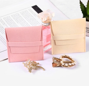 Pink and beige microfiber jewelry pouches with drawstring shown with elegant accessories