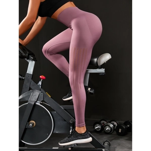 Detail of high waist seamless yoga pants with laser cut breathability on a gym bike