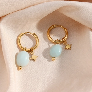 Detail showing gold hoop earrings with blue amazonite and octagram star charms on silk