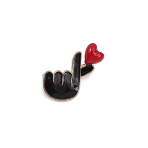 Black heart hand gesture enamel brooch pin with golden outlines on white background