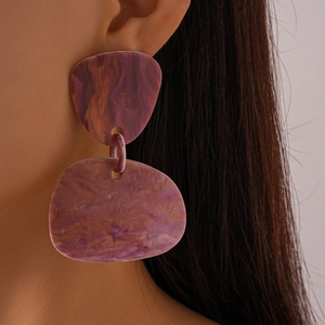 Close-up of resin irregular earrings with purple-brown marble texture on model