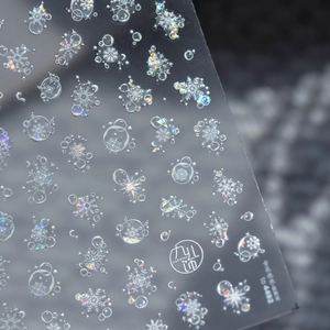 Detailed close-up of 5D embossed laser snowflake and bubble nail art stickers with iridescent glow