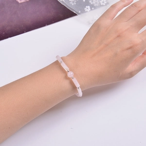 Detailed view of pink quartz beaded bracelet with silver spacers on a wrist