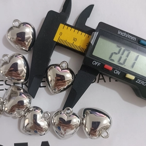 Detailed view of silver heart pendant with digital caliper measuring 20.1mm width