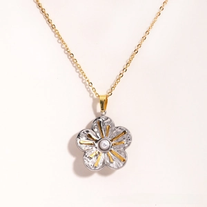 Détail macro d'un collier pendentif pétale vintage avec perle et accents dorés élégants