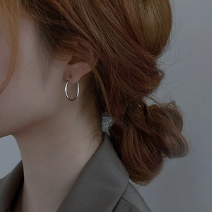 Close-up of elegant S925 sterling silver hoop earring worn on a female model's ear