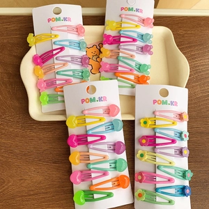 Close-up of macaron-colored children's hair clips in candy and flower shapes on a card