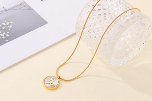 Detailed macro view of golden Capricorn shell necklace with white mother of pearl inlay