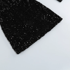 Gros plan du tissu noir à paillettes montrant la texture et le reflet de la robe