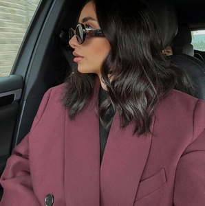 Dettaglio del blazer doppiopetto bordeaux indossato da una modella in auto