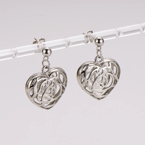 Surgical steel openwork heart stud earrings for women on a transparent display stand