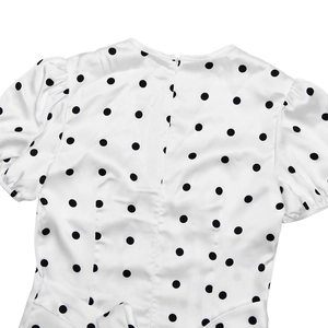 Detail view of white satin puff sleeve dress with black polka dots and back zipper