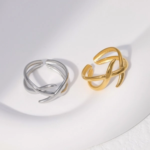 Detail of minimalist criss-cross layered rings in gold and silver finish with open design