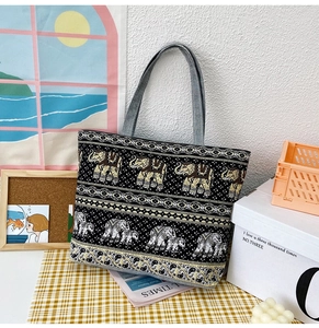 Detail of bohemian black canvas tote bag with elephant print and denim handles