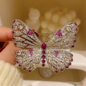 Macro shot of butterfly brooch with silver base and sparkling red ruby gemstones