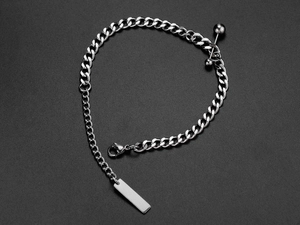 Macro detail of silver titanium steel chain bracelet with ball charm and tag accessory