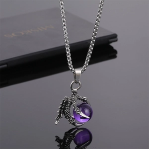 Vue détaillée du pendentif griffe de dragon argenté avec perle violette sur chaîne box