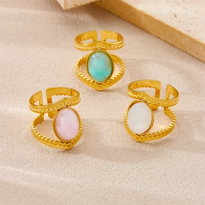 Detailed view of three vintage 18K gold plated rings with pink, blue, and white gemstones