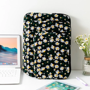 Three sizes of black quilted laptop bags with daisy embroidery and zipper closures