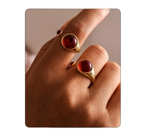 Macro view of gold-plated garnet open ring with deep red gemstones and polished finish