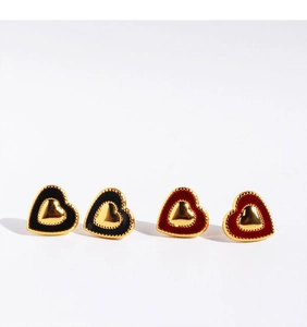 Detailed macro view of heart earrings with red and black enamel and beaded gold edges