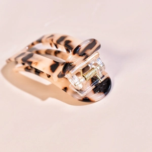 Close-up of tortoise shell pattern acetate hair claw clip with golden metal spring