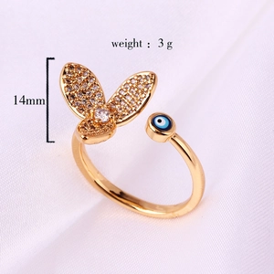 Close-up of gold butterfly and blue evil eye ring with cubic zirconia detailing