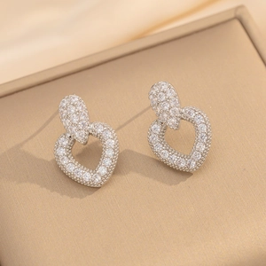 Detailaufnahme herzförmiger Silberohrringe mit fein gefassten Zirkonia-Kristallen im Pavé-Stil
