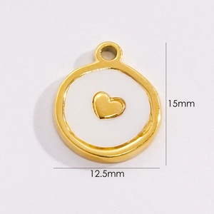 Macro detail of a 12.5mm gold titanium steel round pendant with white shell heart inlay