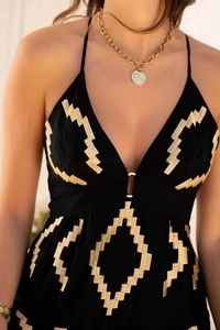Dettaglio dell'abito boho con scollo a V profondo e ricami in oro sul petto