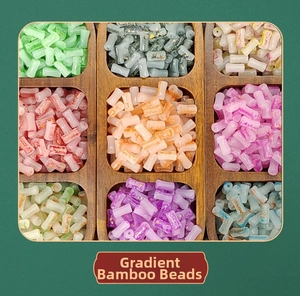 Macro view of multi-colored smudge-dyed bamboo style glass beads in a wooden tray