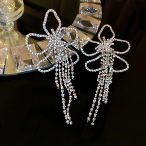 Detailed close-up of crystal butterfly tassel earrings with silver diamond fringe drops