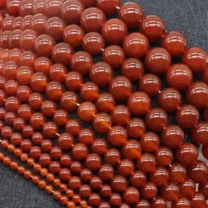Macro view of assorted sizes of polished red agate round loose beads for DIY jewelry making