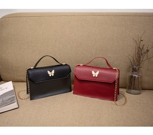 Detail view of mini crossbody bags with butterfly clasps in black and burgundy leather