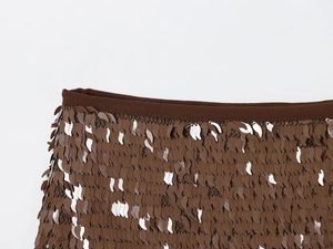 Vue macro de paillettes marron et argentées sur le détail de la taille en tissu résille