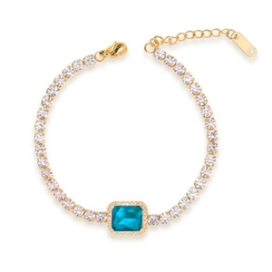 Nahaufnahme von Goldarmband mit blauem rechteckigem Edelstein und weißen Zirkonsteinen