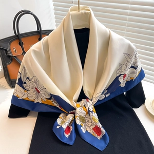 Close-up of elegant floral print twill silk scarf draped on a chic hanger with accessory