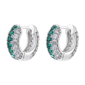 Detailed view of silver huggie earrings with emerald green and clear cubic zirconia